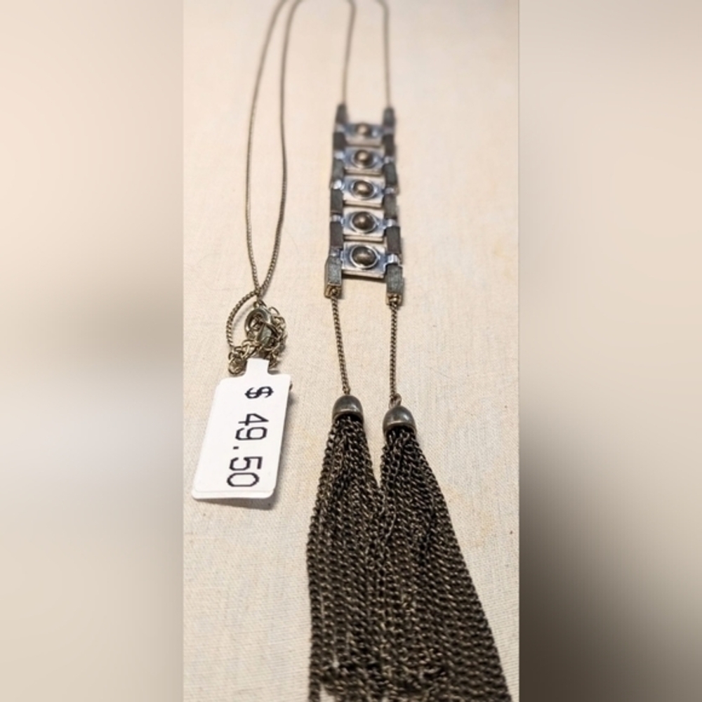 A tall Macy's necklace in brass and silver hues. Tassels add drama.NWT.